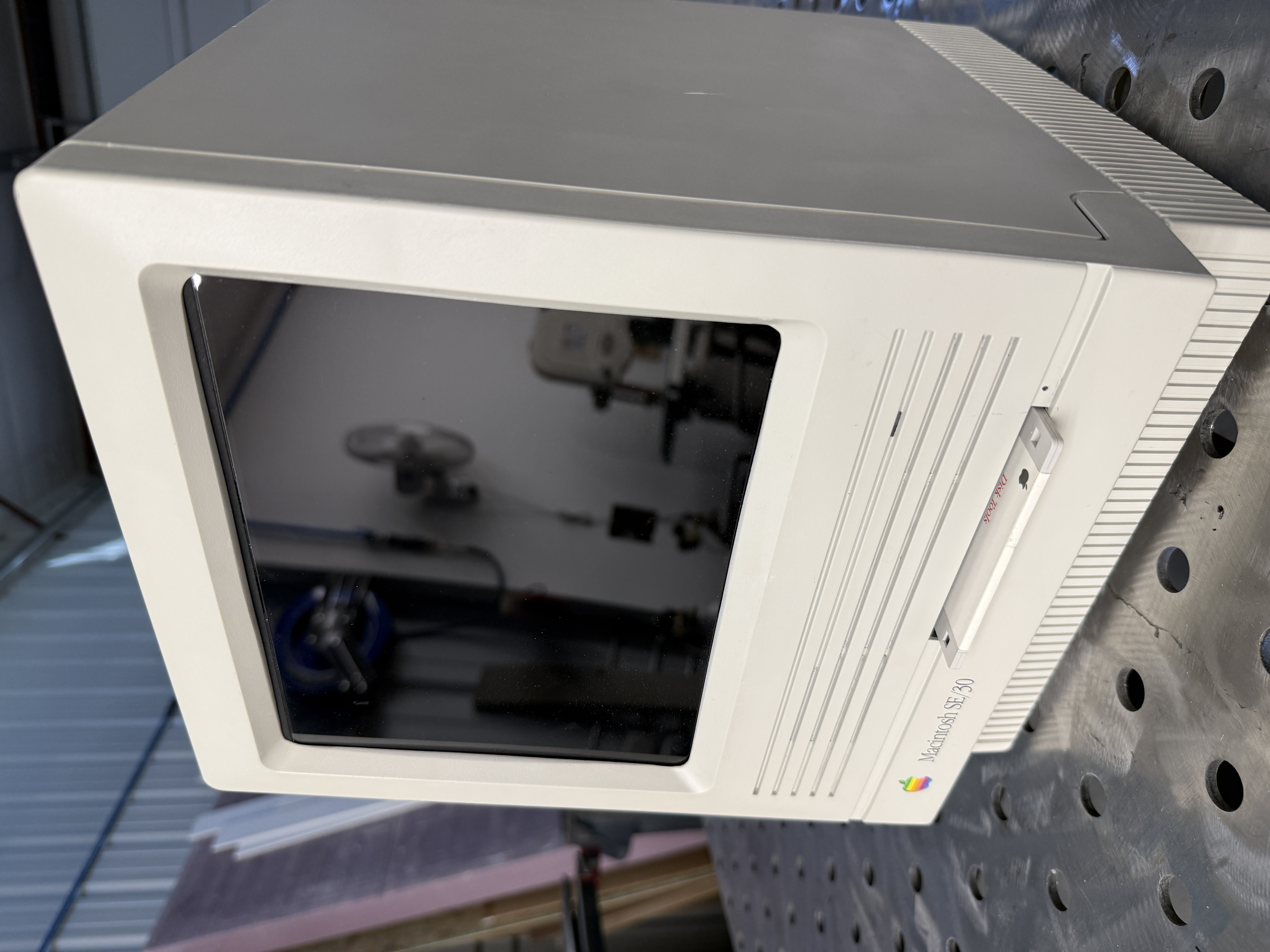 Three-quarter front view of the reimagined SE/30 with a real floppy disk fitted into the original floppy slot