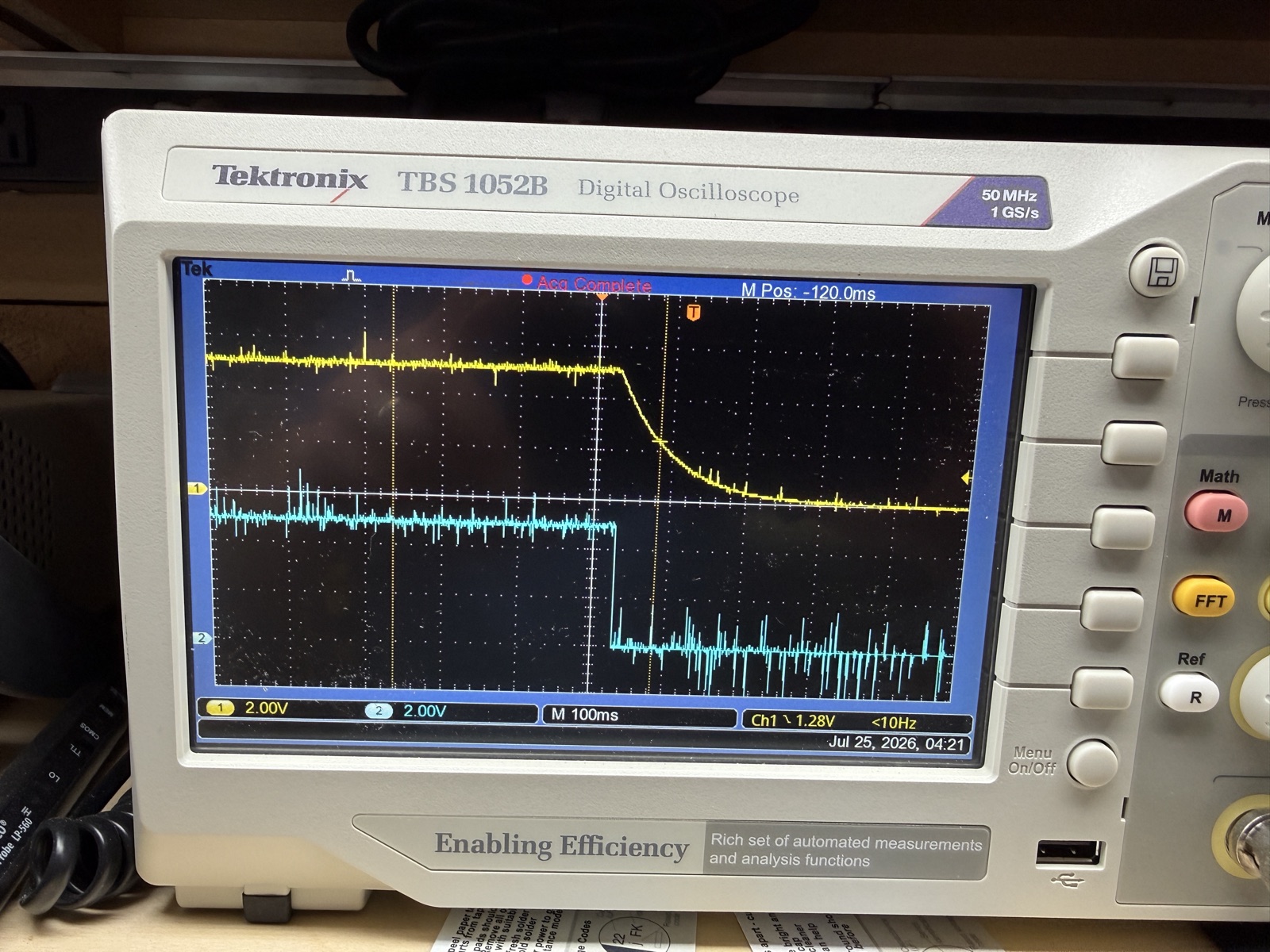 Tektronix TBS1052B single-shot capture: the blue pin 12 status line snaps low in one edge while the yellow +5 rail decays as an RC coast