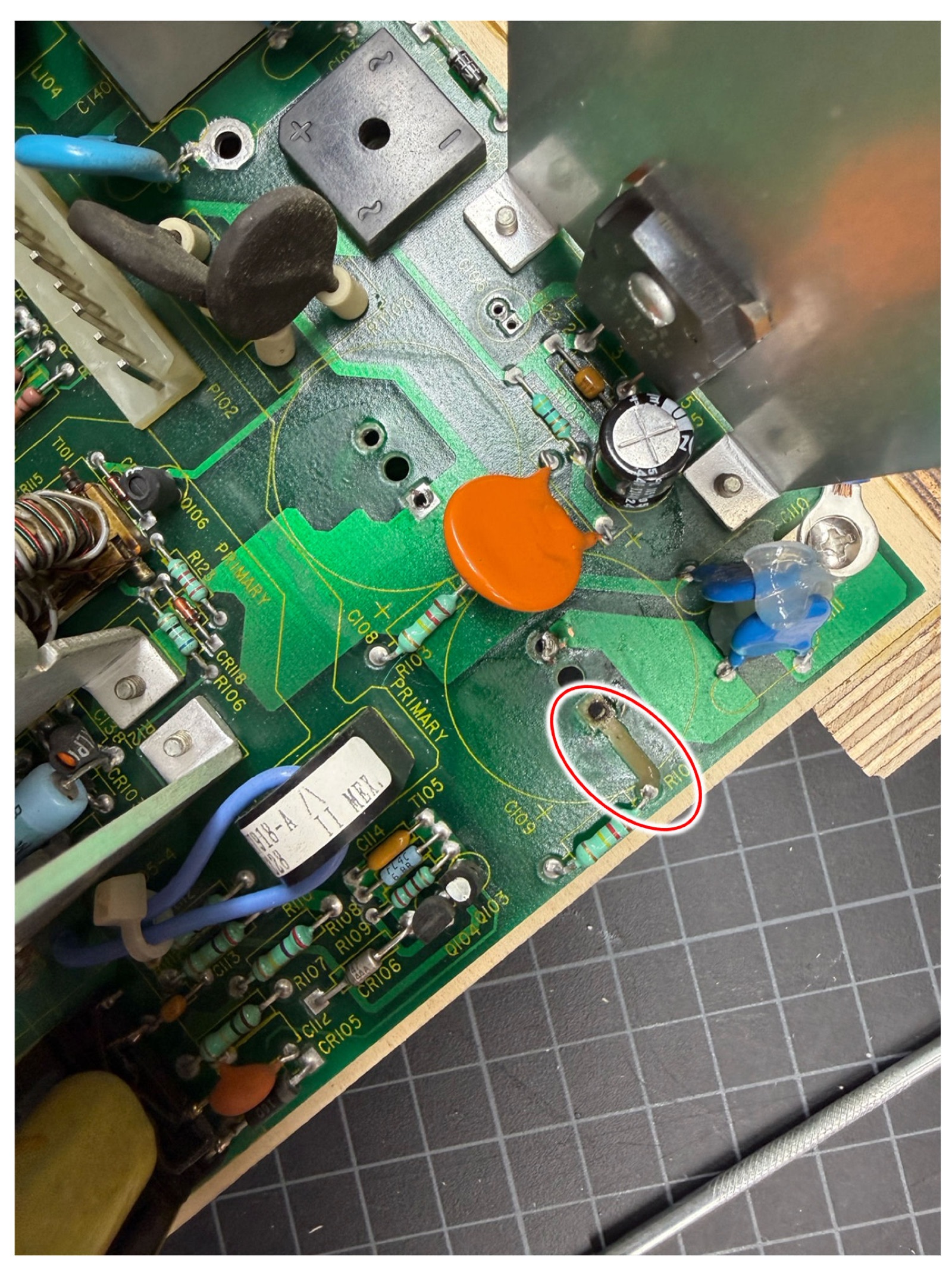 The C109 site on the main board with a red circle marking the broken trace running from the through-hole to a neighboring resistor