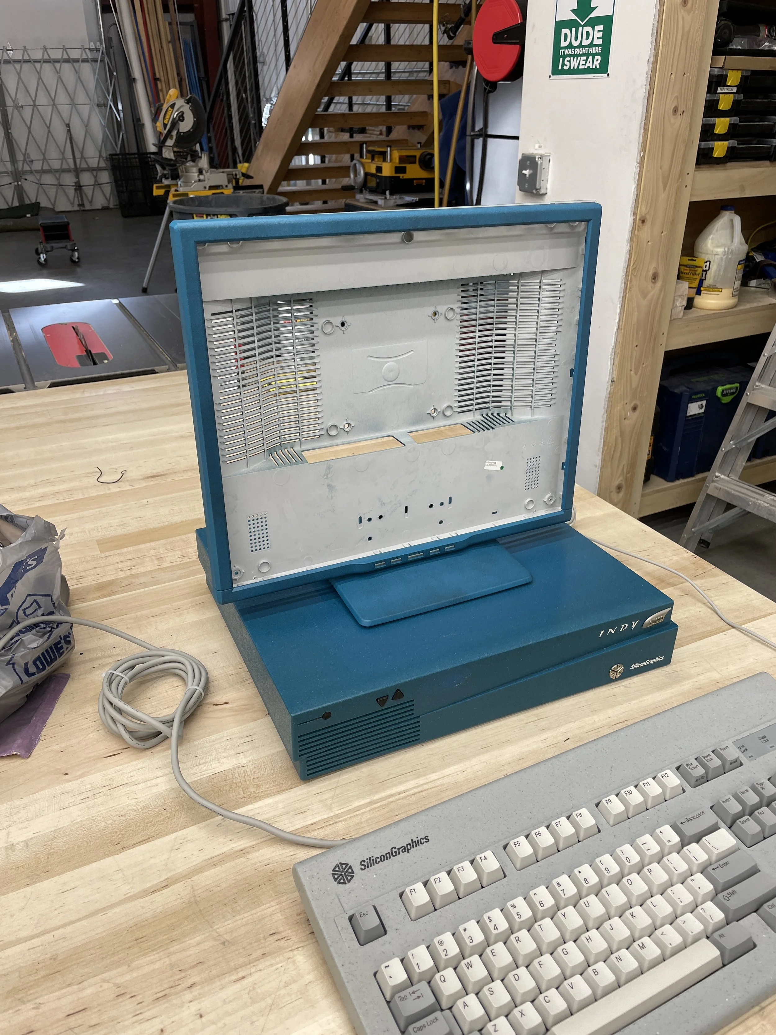 The Sun LCD fully disassembled, bezel separated from the chassis and sitting next to an SGI keyboard