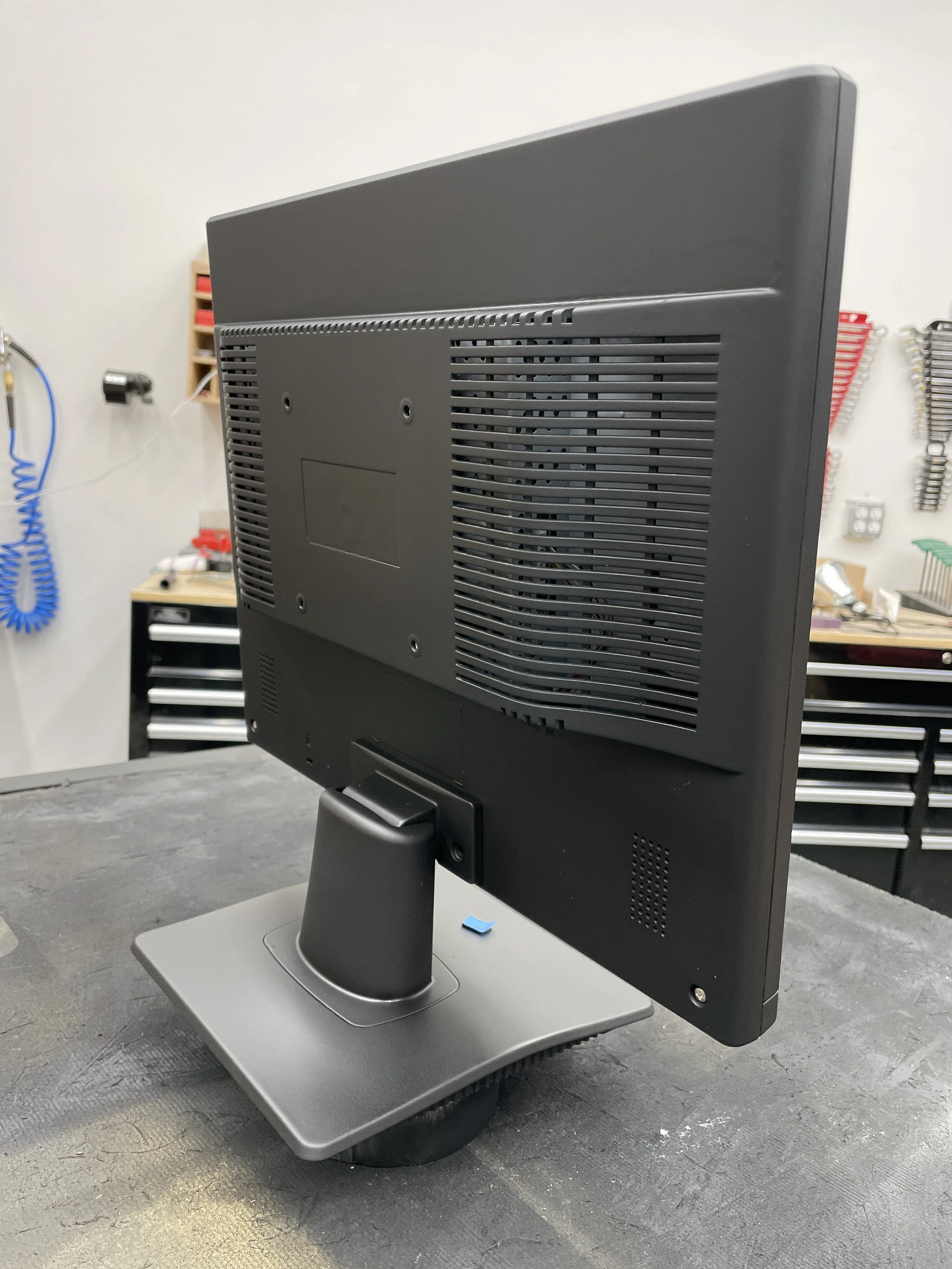 Side/back view of the finished monitor showing the satin black finish on the molded vents and stand